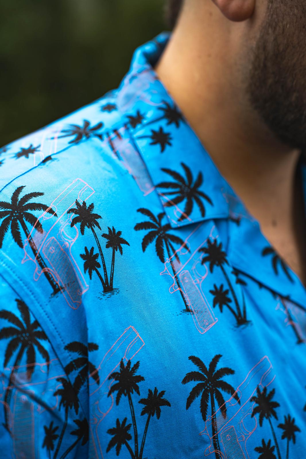 Chemise bleue WesternDream avec motifs palmiers et revolver en transparence, style western moderne et aventure