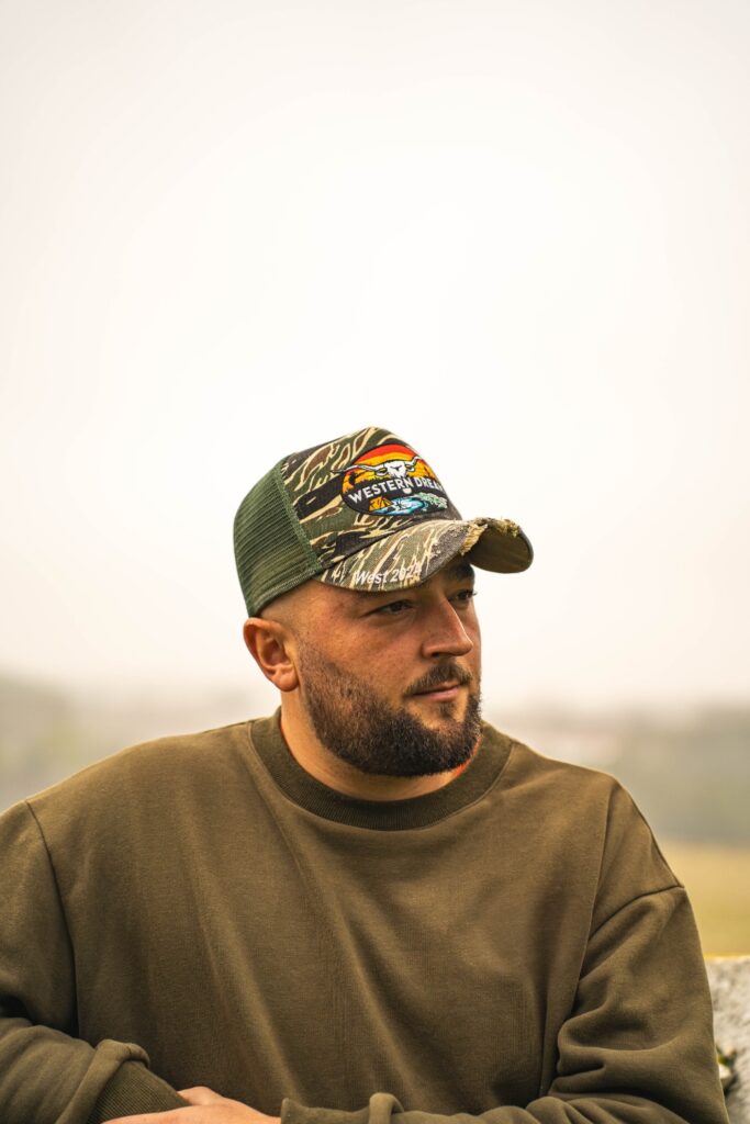 Homme portant une casquette WesternDream kaki camouflage avec logo, style chasse et outdoor