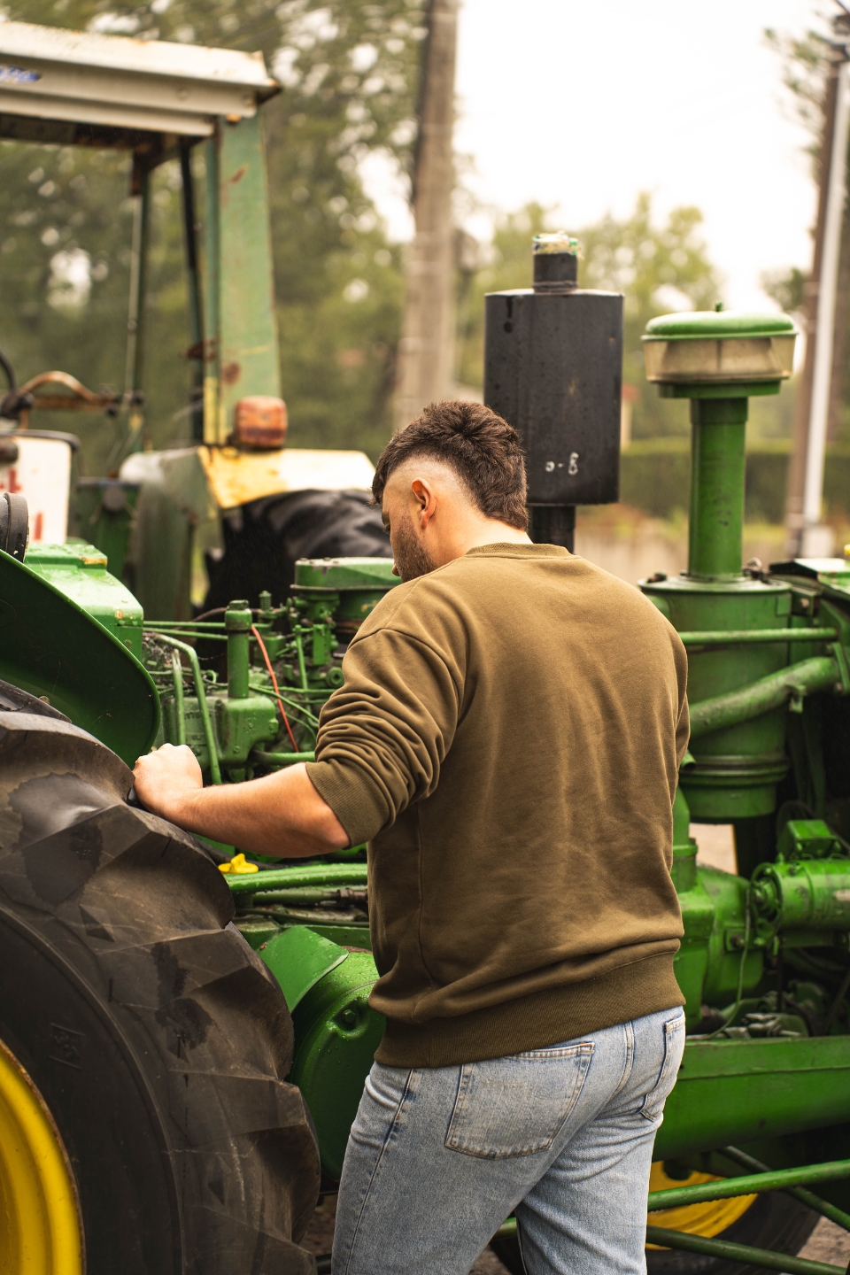 Homme vu de dos portant un sweat kaki Western Dream dans un décor outdoor au style western