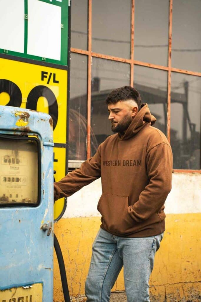 Homme portant un hoodie western marron WesternDream dans un univers outdoor