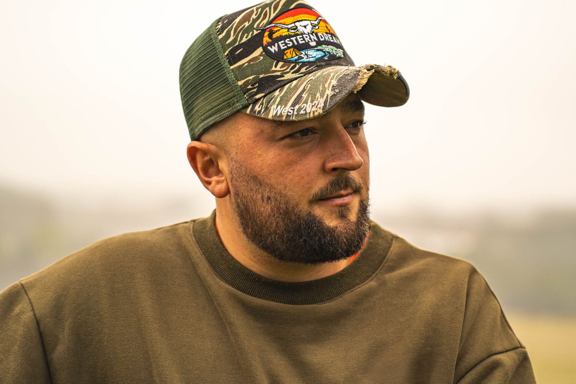 homme barbe portant une casquette trucker style aventure en pleine nature